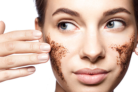 Woman using a coffee scrub on her cheeks, reflecting on the effects of exfoliating products