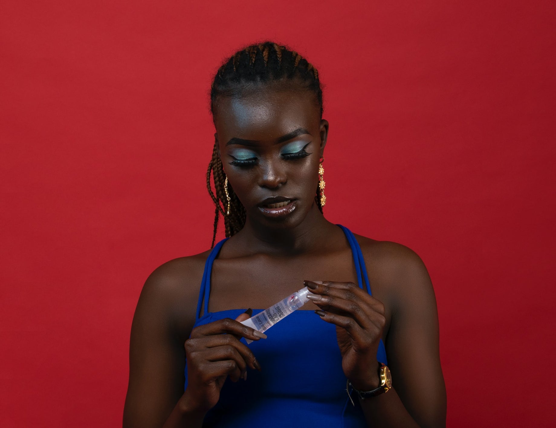 Black woman examining a skincare product for her daily routine.