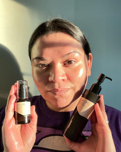 Woman with glowing skin holding Layers products